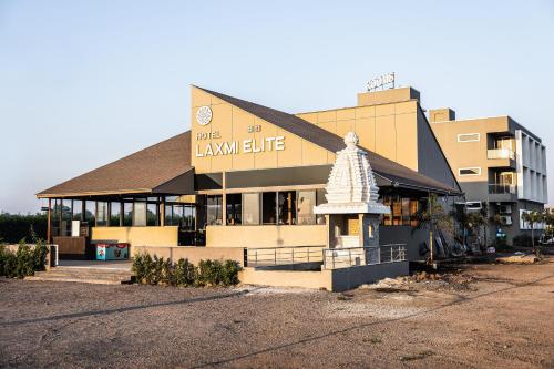 a large building with a sign on top of it at Hotel Laxmi Elite Karad in Karad