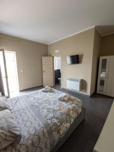 a bedroom with a large bed with a tv on the wall at B&B Roseal in Brusciano