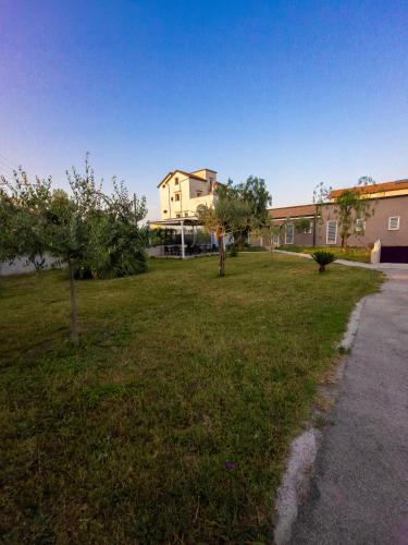 a grassy yard with trees and a building at B&B Roseal in Brusciano
