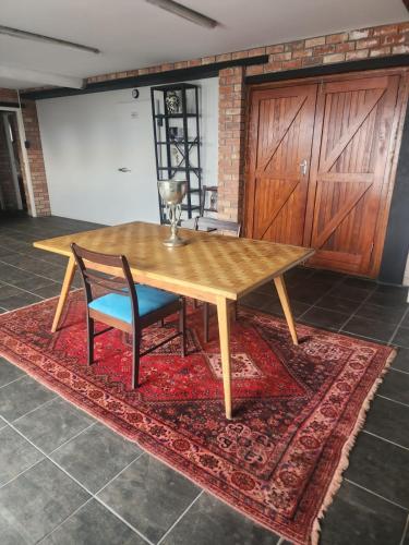 a wooden table and two chairs on a rug at Mount Rd Ocean View in Gqeberha