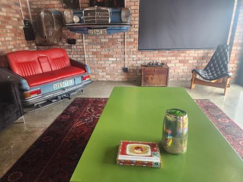 a living room with a green table and a red chair at Mount Rd Ocean View in Gqeberha