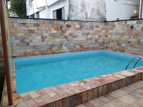 a swimming pool with a brick wall at Pousada do Chafariz in Mariana