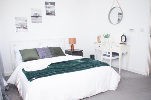 a white bedroom with a bed and a desk at Luxe stylish stay in central Manchester in Manchester