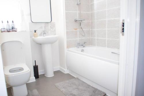 a white bathroom with a toilet and a sink at Luxe stylish stay in central Manchester in Manchester