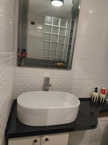 a white sink in a bathroom with a mirror at Elen White Apartment in Rēzekne