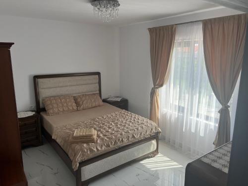 una camera da letto con un letto e una grande finestra di Furnicuta a Curtea de Argeş