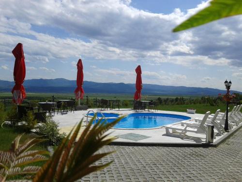 a pool with chairs and tables and umbrellas at Gledkata Complex in Skobelevo