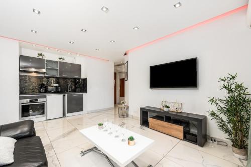 un salon avec un canapé et une télévision sur un mur dans l'établissement Mimosas Lovers, à Cannes