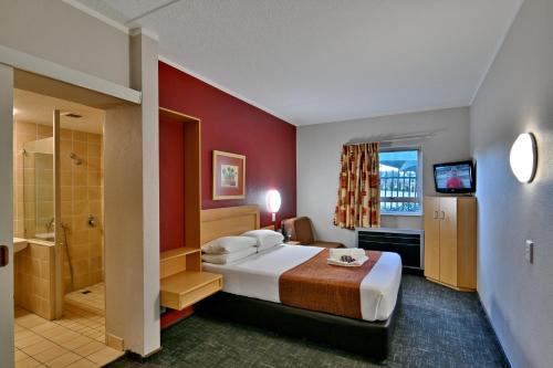 une chambre d'hôtel avec un lit et une salle de bain dans l'établissement Road Lodge JNB Airport, à Johannesbourg