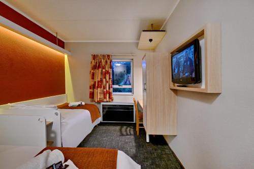 a hotel room with two beds and a flat screen tv at Road Lodge JNB Airport in Johannesburg