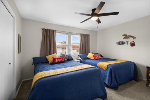 a bedroom with two beds and a ceiling fan at Beach Rendezvous in Navarre