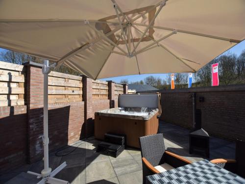 a large umbrella on a patio with a grill at Luxury house in South Limburg near forest in Walem