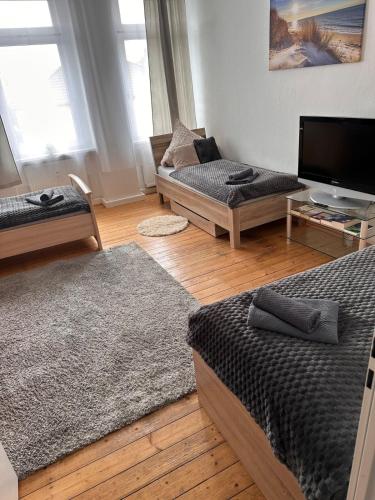 a living room with two beds and a flat screen tv at Apartment on Elbe bike path in Magdeburg