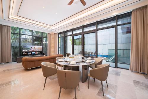a dining room with a table and chairs at 三亚海棠湾蔚蓝海湾公寓 in Sanya