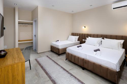 a bedroom with two beds and a desk and a television at Vila Erti Berat in Berat