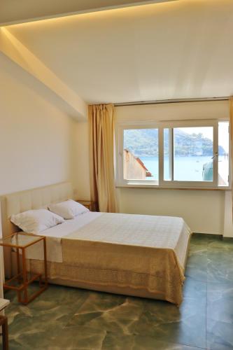 Un dormitorio con una cama grande y una ventana. en Scilla Luxury Rooms, en Scilla