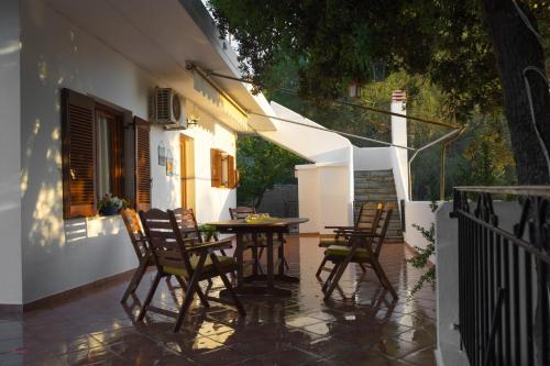 eine Terrasse mit Stühlen und einem Tisch auf der Veranda in der Unterkunft Villa Mitsa in Kolios