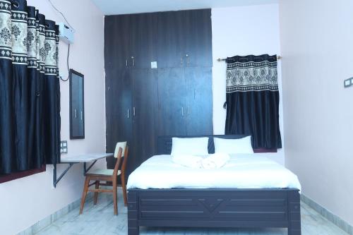 Awe venues في مادوراي: غرفة نوم مع سرير مع كرسي ومكتب