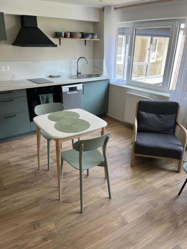 a kitchen with a table and two chairs and a sink at Joli appartement au centre de Nieppe in Nieppe