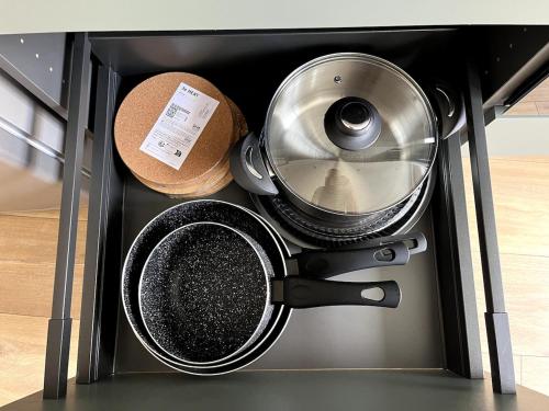 a drawer filled with pots and pans in a kitchen at Joli appartement au centre de Nieppe in Nieppe