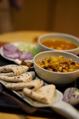 a table with a plate of food and bowls of food at The Cozy Monks - Tirthan Valley in Gushaini
