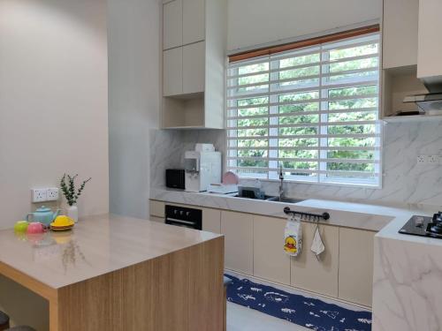 eine Küche mit Theke und Spüle und einem Fenster in der Unterkunft Villa Mun Homestay with 3 bedrooms 3 bathrooms in Kota Bharu
