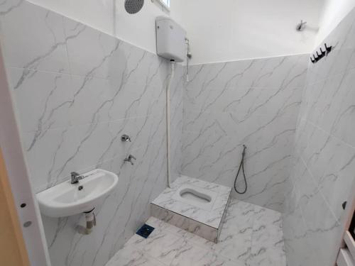 ein weißes Badezimmer mit Waschbecken und Toilette in der Unterkunft Villa Mun Homestay with 3 bedrooms 3 bathrooms in Kota Bharu