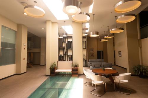 a lobby with a table and chairs and a couch at Urban Green Hotel & Suites in San José