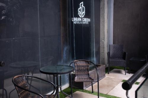 a table and chairs in a room with a sign on the wall at Urban Green Hotel & Suites in San José