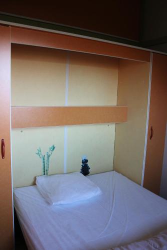 a bed with white sheets and a wooden headboard at Camping Le Balcon de Chartreuse in Miribel-les-Échelles