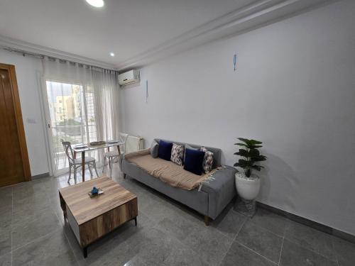 a living room with a couch and a table at Pépite au cœur du Belvédère Tunis in Bāb as Suwayqah