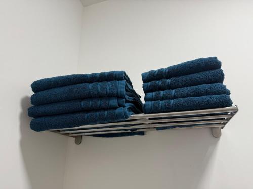 a rack with blue towels on top at Petit appartement central Chimay in Chimay