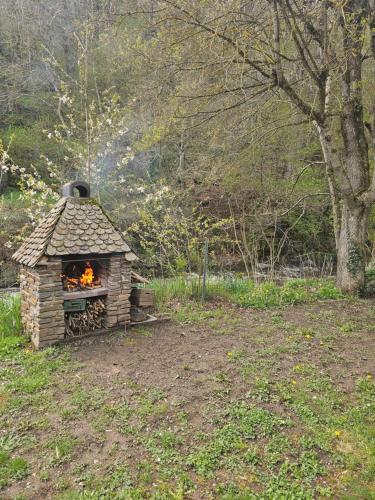 a brick oven with a fire in it in a field at Moulin au Bord de l'Eau Calme et Nature in Saint-Léger-de-Peyre