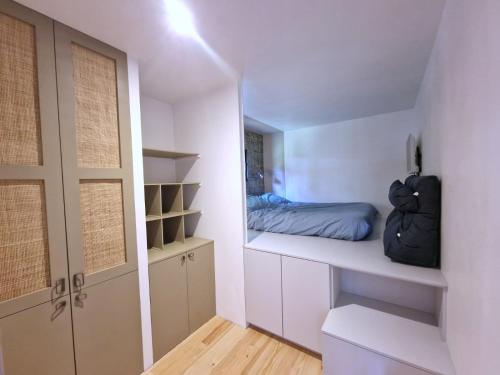 - une chambre avec un lit sur une étagère blanche dans l'établissement Mini maison sur pilotis, à Saint-Jorioz