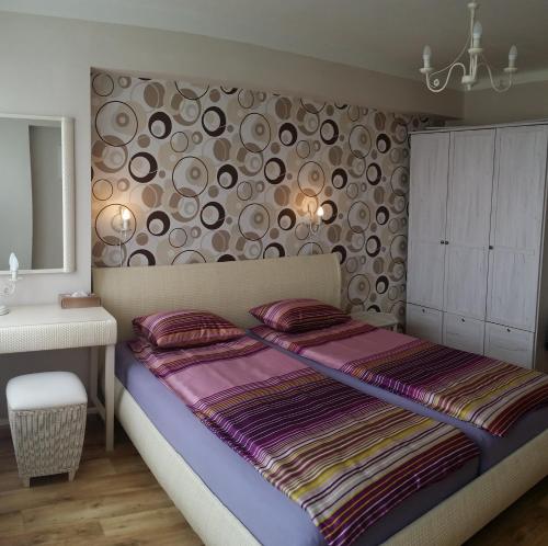 a bedroom with a large bed and a wall with circles at Veles Apartment in Prague