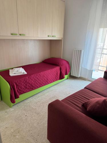 a bedroom with a bed with a red bedspread and avertisement at MERAVIGLIOSO in Polignano a Mare