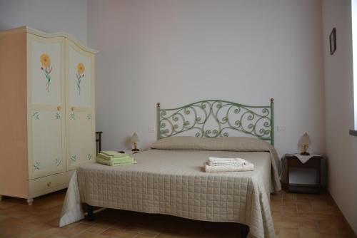 a bedroom with a large bed and a dresser at Casale Fusco in Spoleto