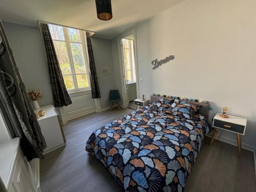 une chambre avec un lit avec une couette dessus dans l'établissement Appartement dans le Beaujolais, à Villefranche-sur-Saône