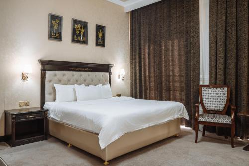 a hotel room with a bed and a chair at Daniel Hill Hotel in Tashkent