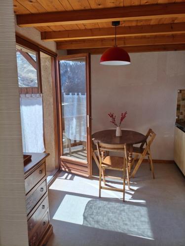 une cuisine avec une table avec un vase dessus dans l'établissement Les Soleils de la Meije, à La Grave