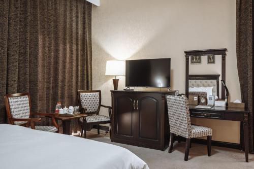 a hotel room with a bed and a desk with a computer at Daniel Hill Hotel in Tashkent