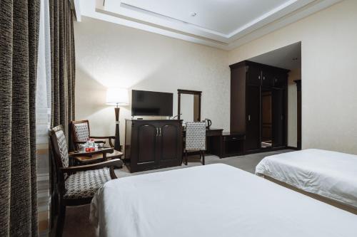 a hotel room with a bed and a desk at Daniel Hill Hotel in Tashkent