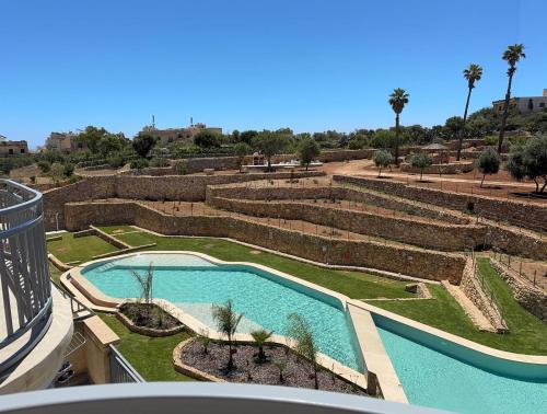 a view of a swimming pool in a garden at Wardija Heights Luxury Penthouse in Qala