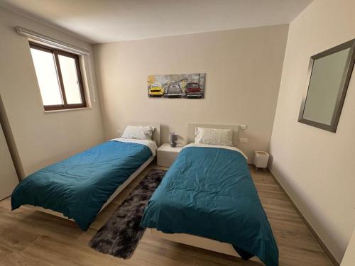 a bedroom with two beds and a mirror at Wardija Heights Luxury Penthouse in Qala