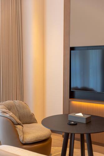 a living room with a table and a tv at Mlily Hotel in Shanghai