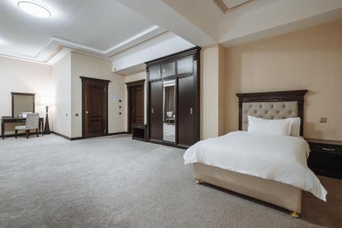 a large bedroom with a bed and a desk at Daniel Hill Hotel in Tashkent