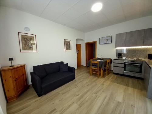 un soggiorno con divano e cucina di Il Nido dell'Adriana Apartment a Ledro