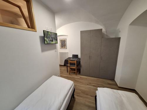 una piccola stanza con due letti e una scrivania di Il Nido dell'Adriana Apartment a Ledro