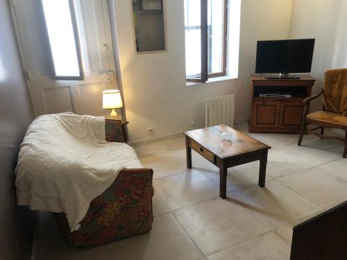 a living room with a bed and a coffee table at La maison de jeanne in Vauvert