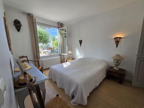 une chambre avec un lit blanc et une fenêtre dans l'établissement La Caravelle grande villa vue mer piscine 5x11, aux Issambres